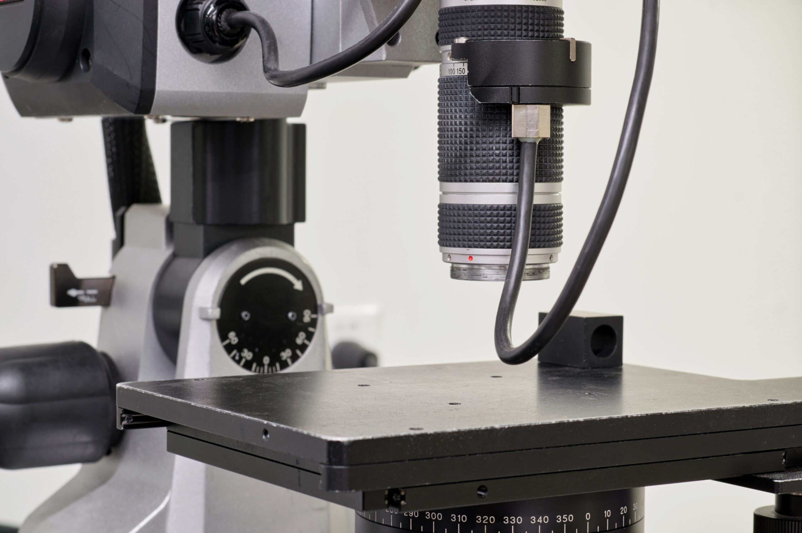 Digital microscope in a laboratory with selective focus on the lens. Isolated science and research lab equipment with no people.